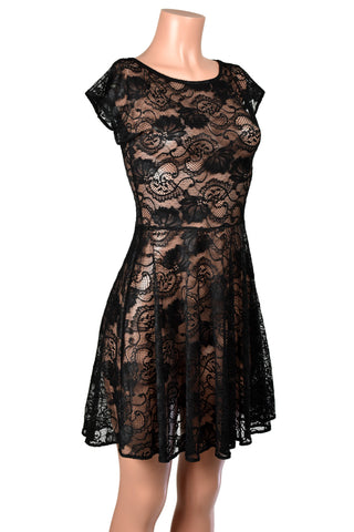 Mannequin wearing Sheer Black Stretch Lace Skater Dress. Dress has a seam at the waistline, wide neckline, cap sleeves, and flared skirt section.