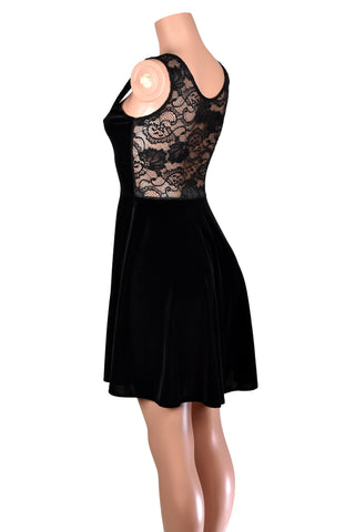 Side back view of mannequin wearing black sleeveless velvet skater dress with sheer black lace back